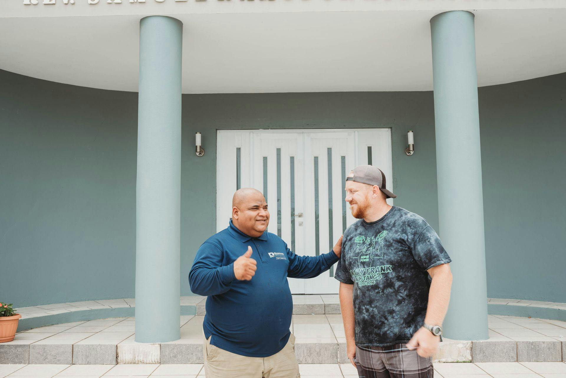 Two pastors outside of a church. 